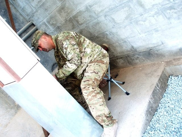 Man in camo uniform sitting on slacker chair.